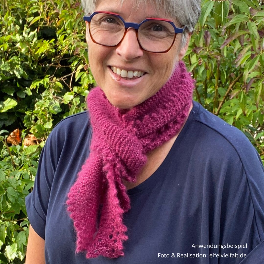 handgestrickter Schal in der Farbe Erika mit einem gezackt-gestrickten Picotrand am Hals einer Frau