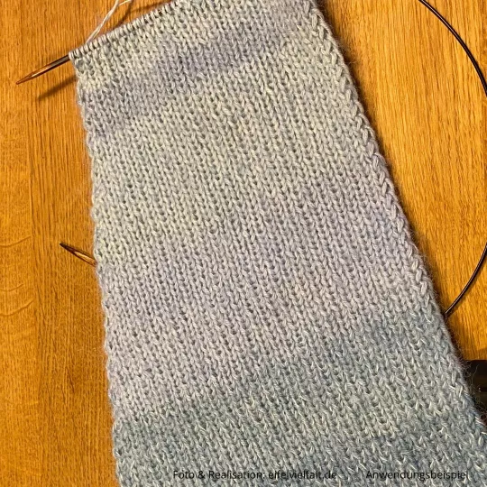 Schal im Anstrick ausgebreitet auf einem Holztischd 