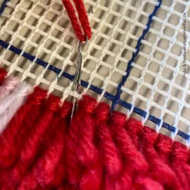 Knüpffaden wird durch das Stramin gezogen Knüpffaden wird durch das Stramin gezogen