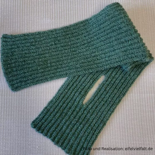 handgestrickter Steckschal Kermeter zusammengelegt mit sichtbarem Schlitz zum Durckstecken des Schalendes