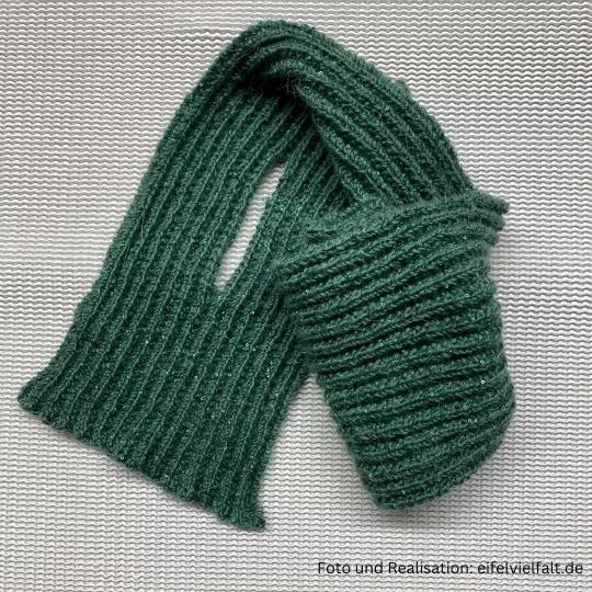 tannengrüner Steckschal mit sichtbarem Schlitz teilweise zusammengerollt mit rechten und linken Maschen gestrickt