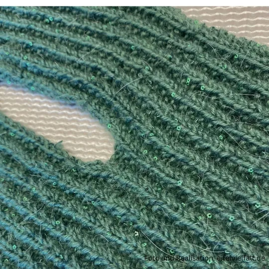 Steckschal Kermeter liegt flach und zeigt den zu strickenden Schlitz