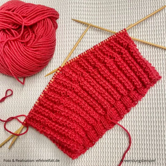 Rippenbündchen mit verdrehtem Rippenmuster aus roter Merinowolle  auf dem Nadelspiel