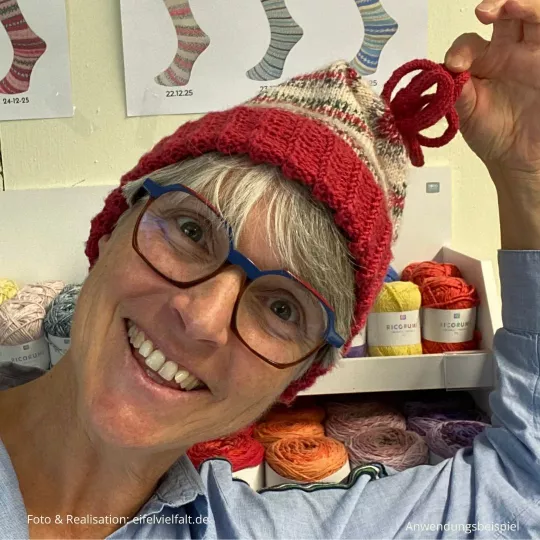 Weihnachtsmütze Vilsalpsee getragen von einer Frau mit grauen Haaren und blau-roter Brille