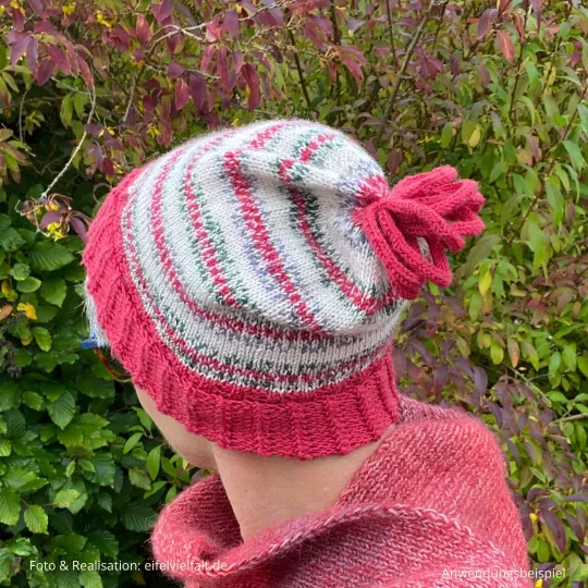 Frau trägt fertig gestrickte Weihnachtsmütze Vilsalpsee vor einer Hecke