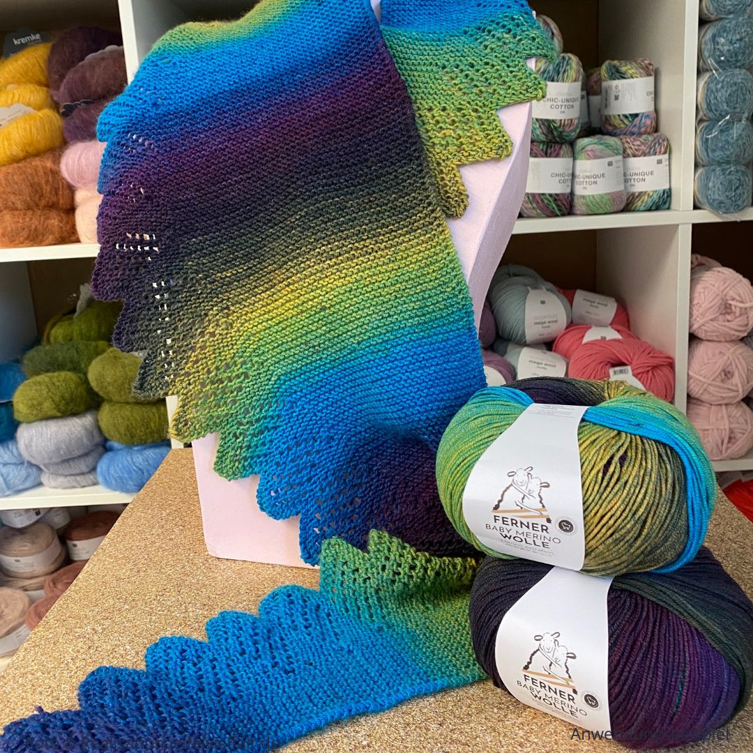 Baby Merino Verlaufsfarben von Ferner als Dreieckstuch mit Lochmusterzacken verstrickt und auf einer Büste drapiert mit den dazu passenden Wollknäuel