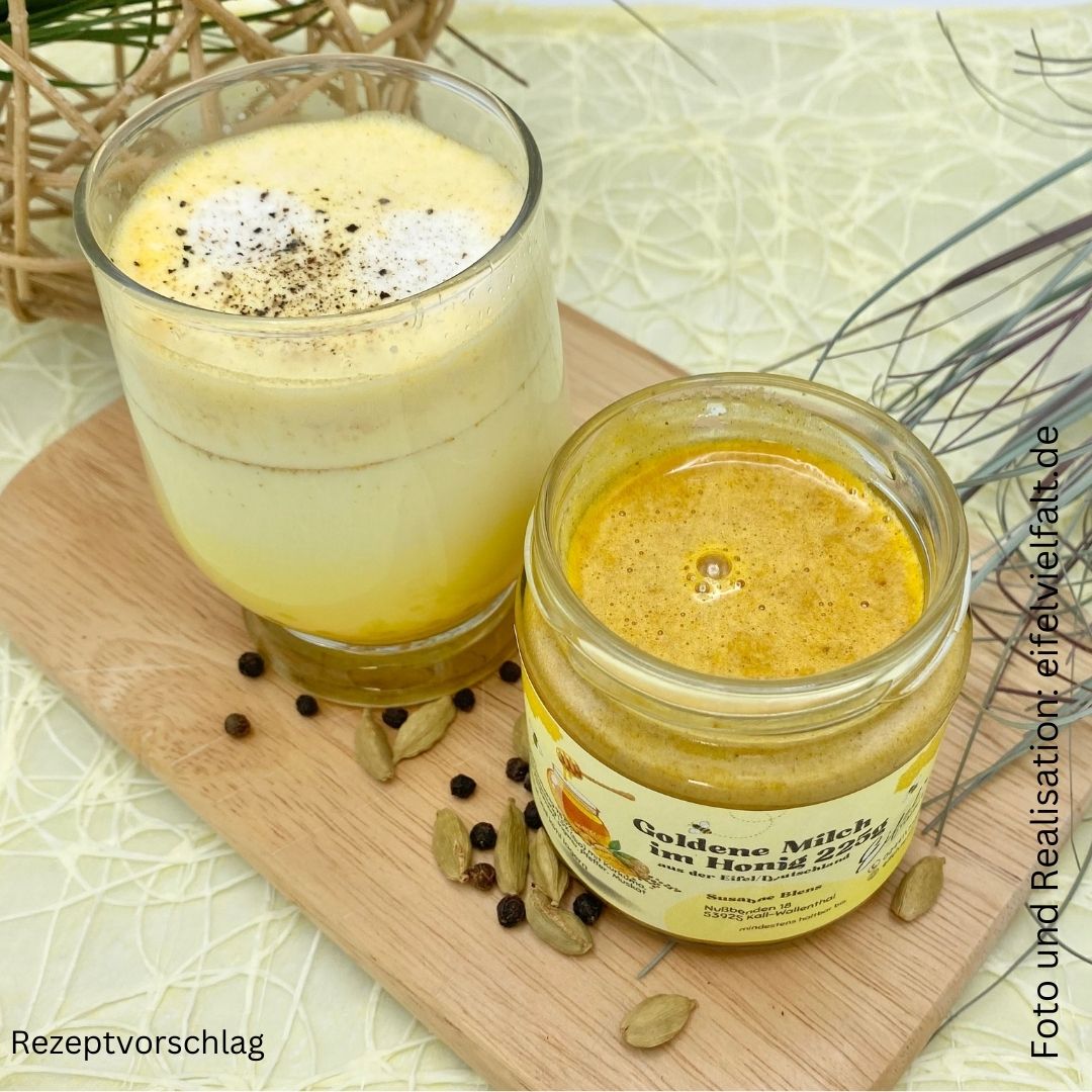 Goldene Milch im Honig im 225g Glas auf Holzbrett dekoriert mit Kardamom und schwarzem Pfeffer und einer zubereiteten MIlch von oben 